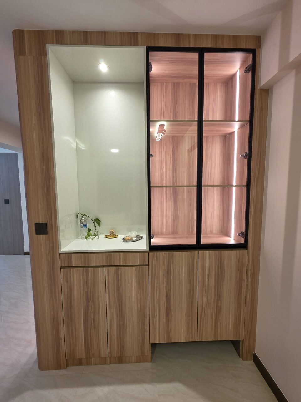 Entry unit with white altar niche and lit black-framed curio cabinet