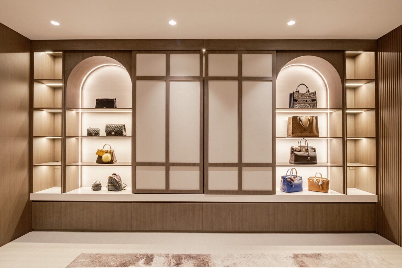 Backlit arched display niches staging a designer handbag collection