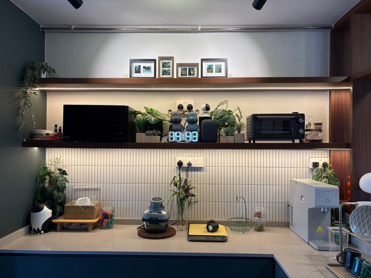 Petrol-blue kitchen with finger-mosaic backsplash and floating walnut shelves