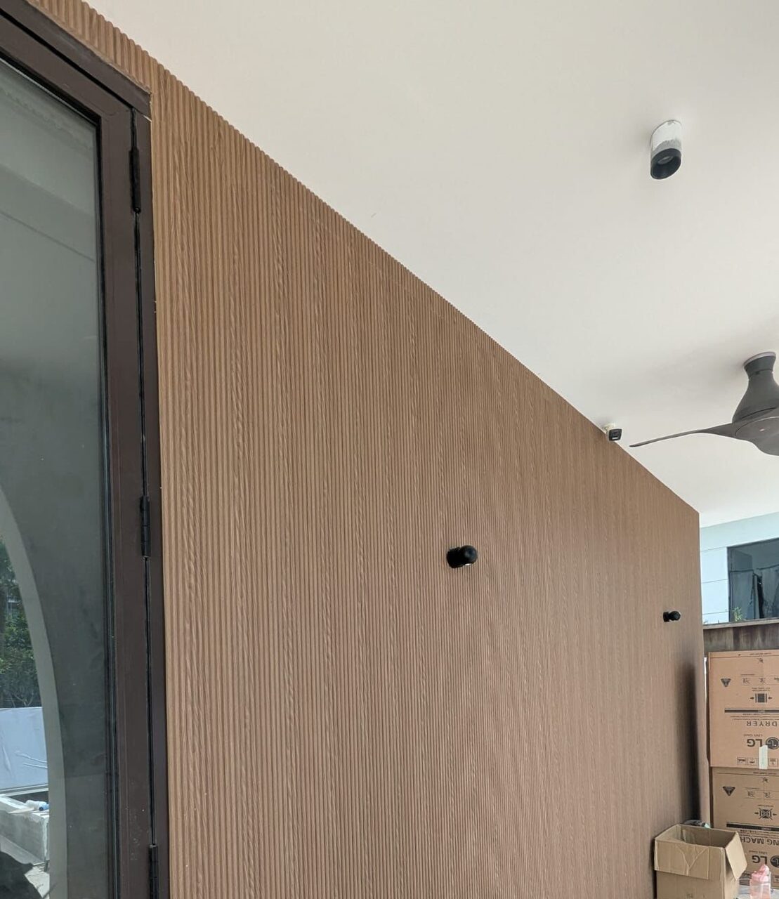 A full run of fluted WPC cladding beside the glass sliders