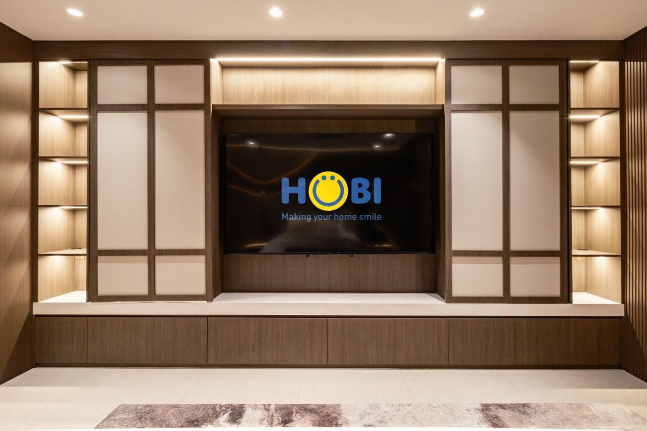 Recessed TV bay flanked by shoji panels and lit oak shelving