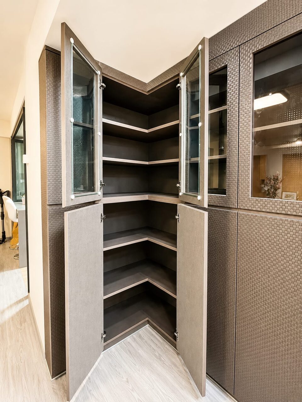Open corner cabinet revealing angled L-shaped shelving in a charcoal-lined interior