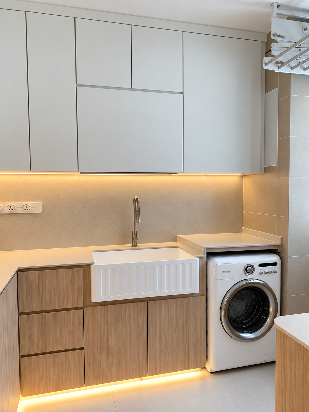 Kitchen laundry zone — farmhouse sink + washer, white upper cabs, LED strips