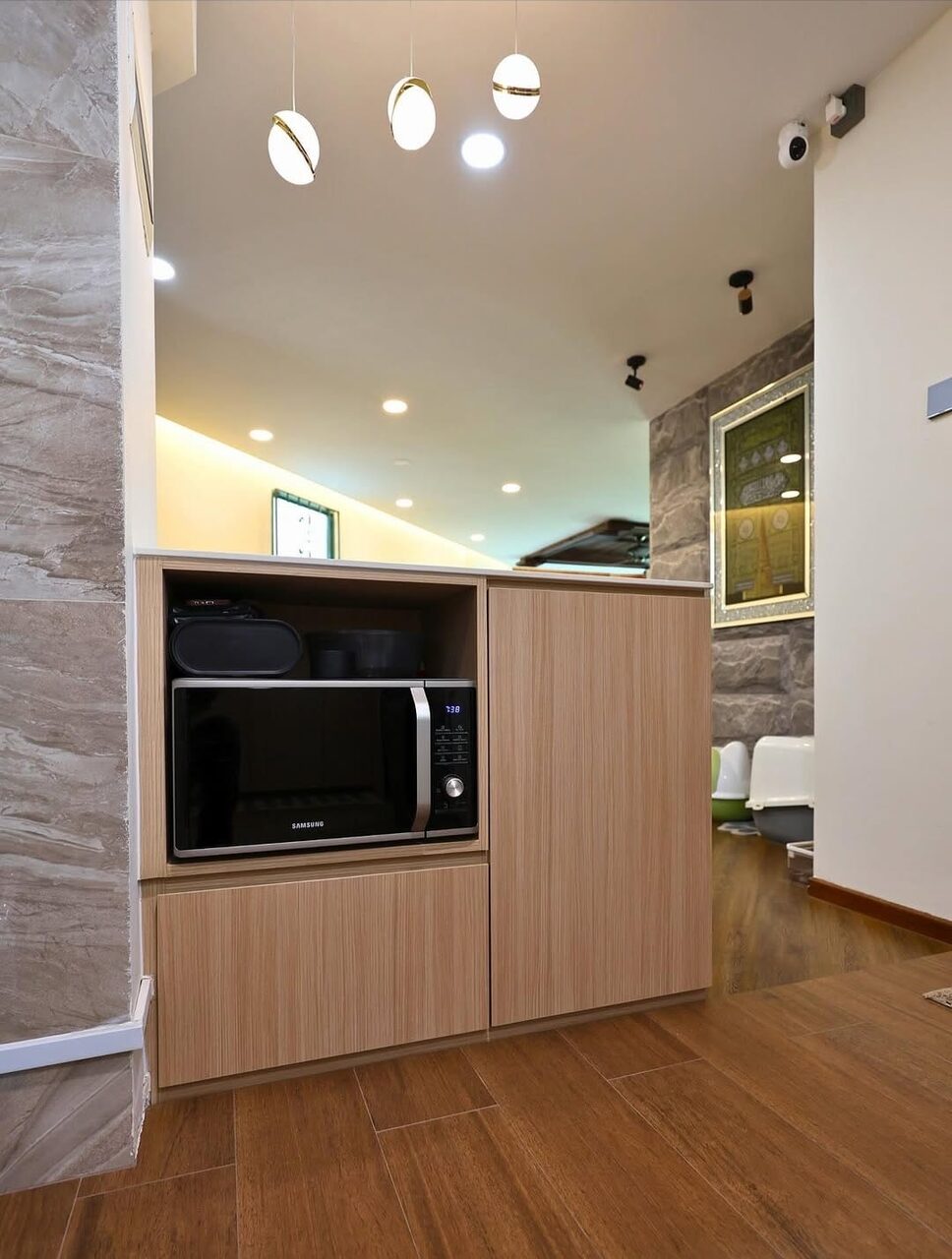Light-oak tall cabinet housing the microwave and appliances