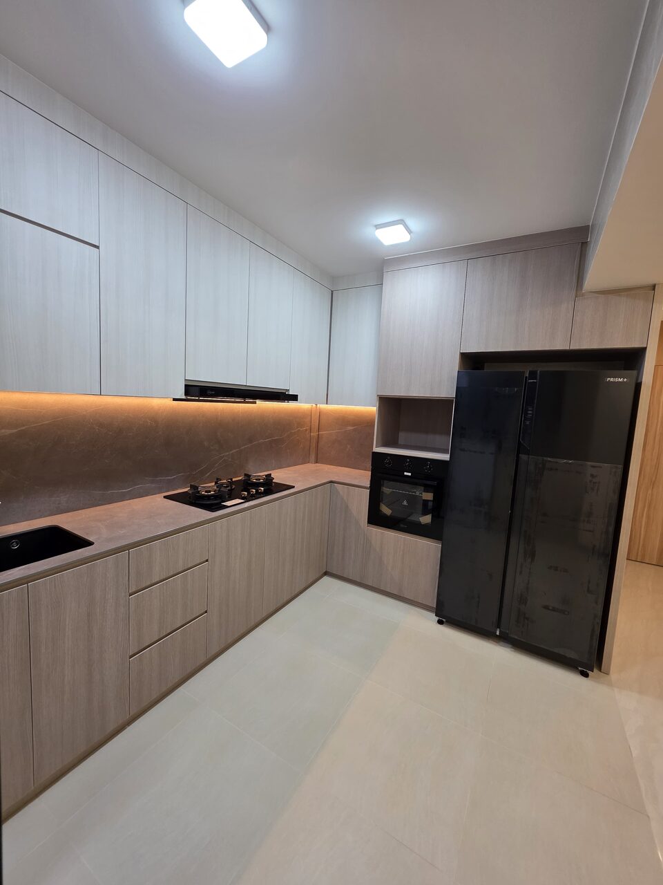 Greige woodgrain kitchen with coffee-marble backsplash and black appliances