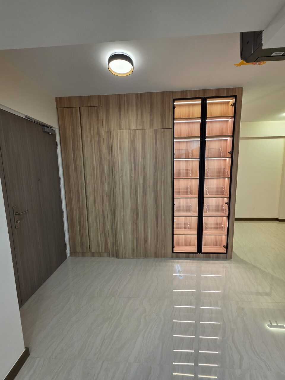 Display wall in context — glass cabinet beside a full-height wardrobe