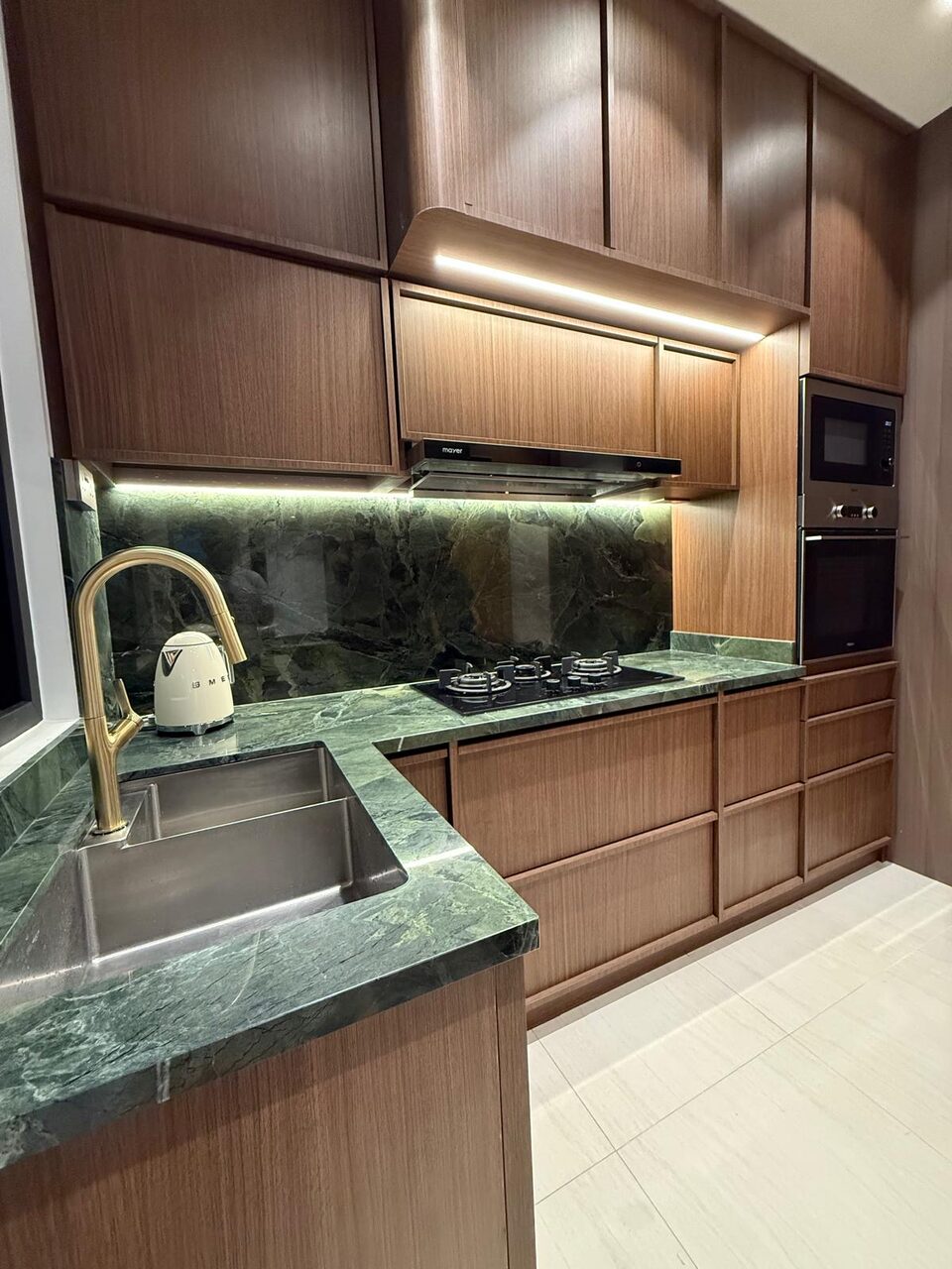 Walnut kitchen with green marble and brass tap