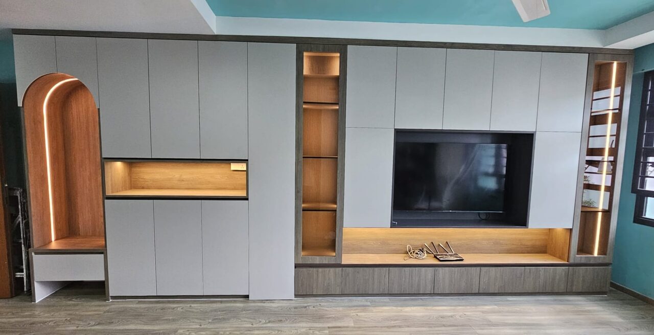 Full wall of stone-grey storage with a lit oak display shelf