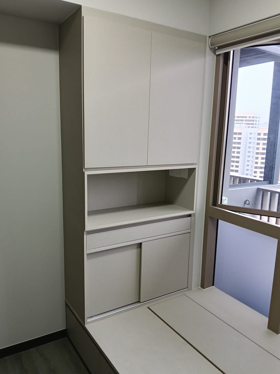 Fitted taupe storage cabinet by the window