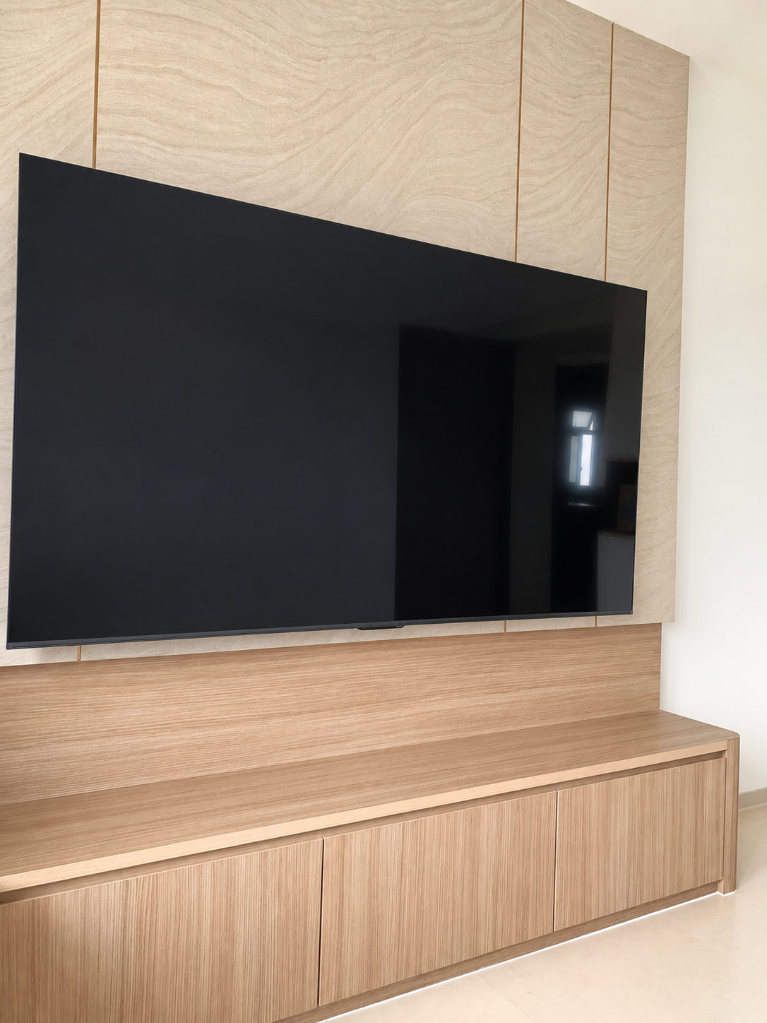 TV feature wall close-up — oak upper cabinets and low console