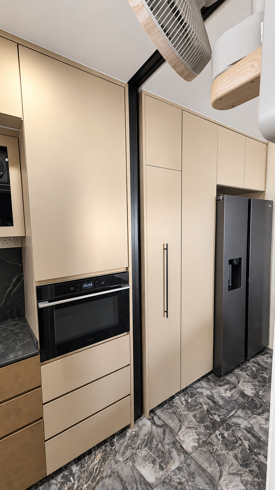 Cream kitchen with oven tower, LG fridge and black marble worktop