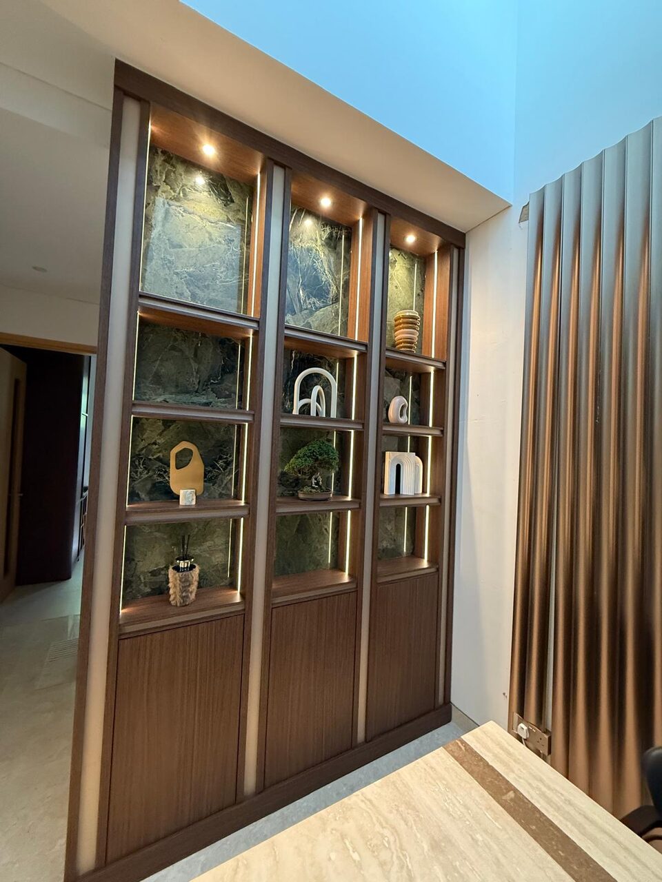 Backlit walnut and green-marble display wall