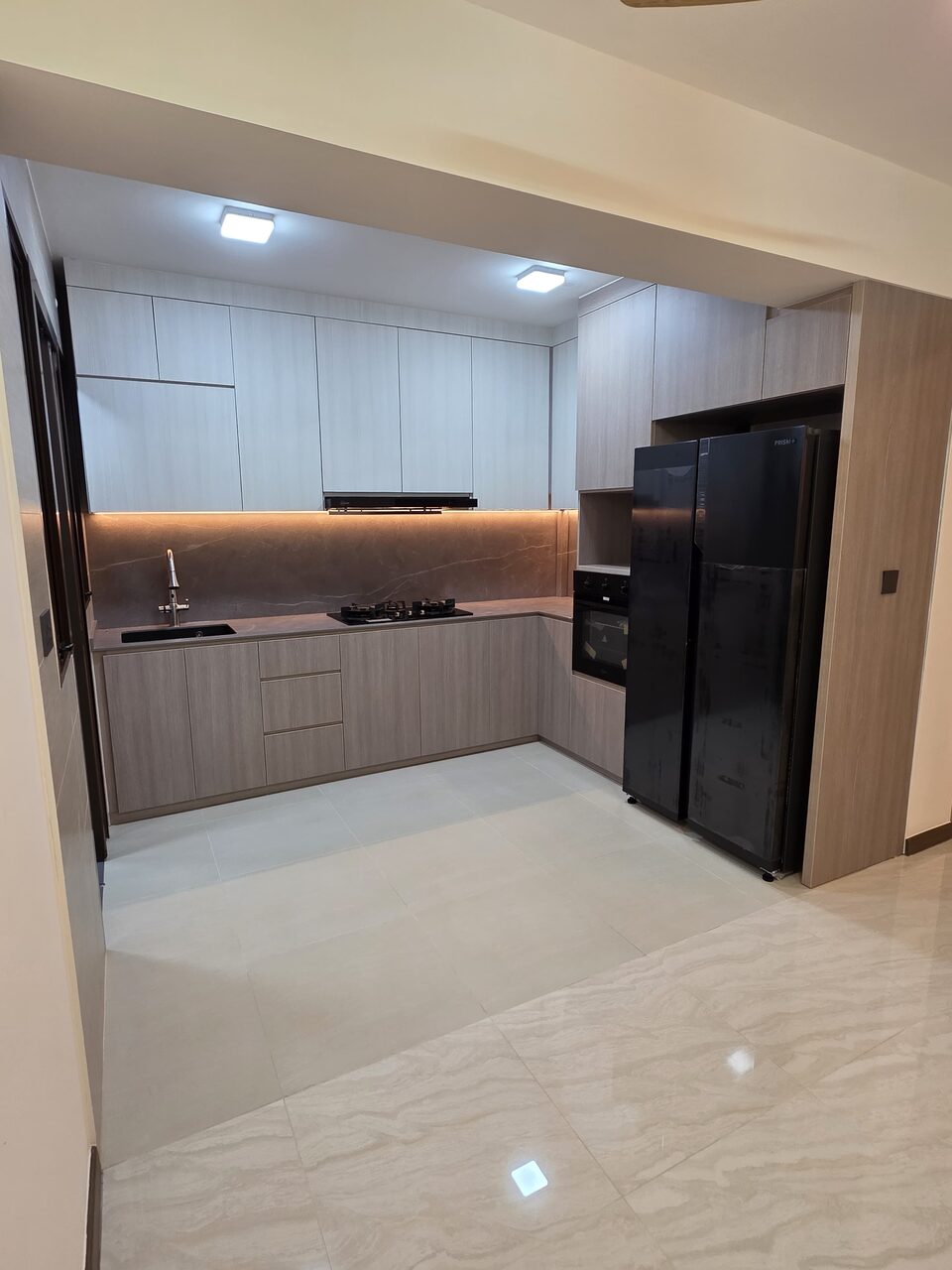 Kitchen from the entry — fridge, oven and full-height storage