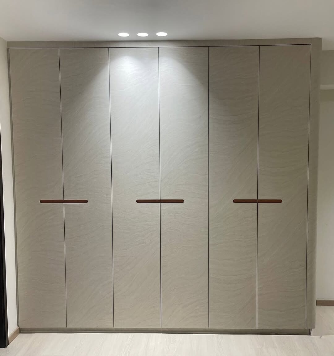 Floor-to-ceiling sandstone-wave wardrobe with copper inlay handles