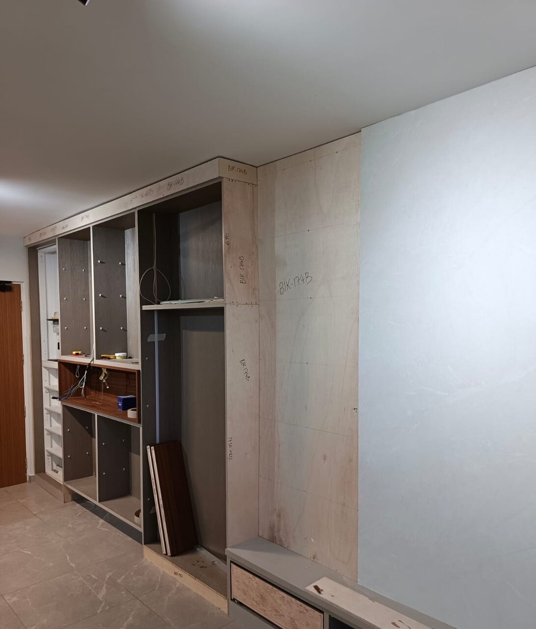 Open-shelf carcass mid-build with walnut panel ready to install