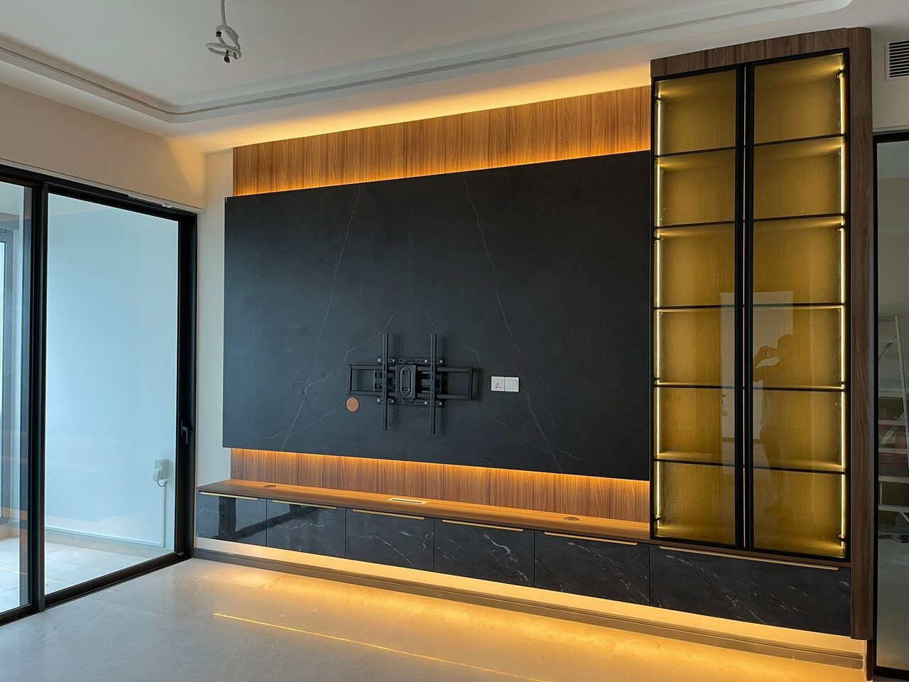 Perfect Ten condo — charcoal-stone and walnut TV feature wall, lit