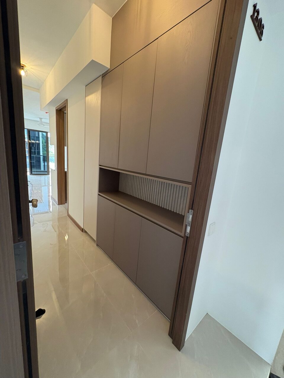 Greige entry cabinetry with fluted niche