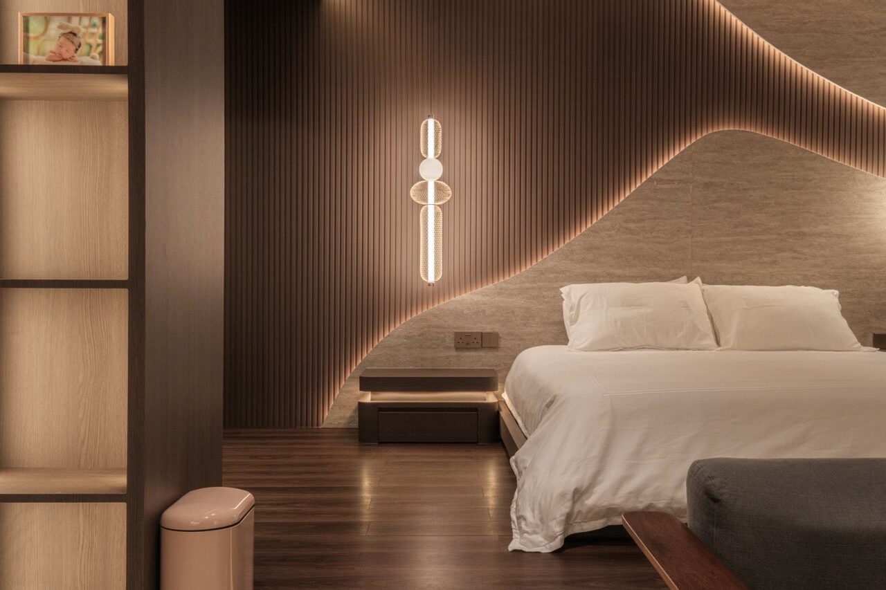 Wave-cut travertine headboard with orb pendant over the platform bed